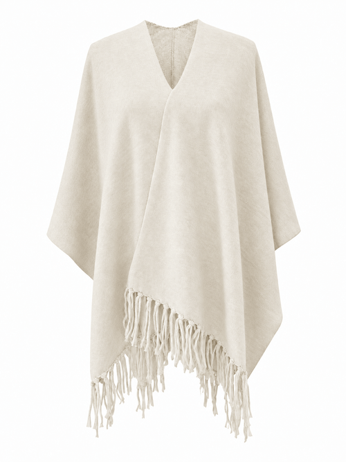 A cream-colored knit poncho with a V-neck and fringed hem, displayed on a clean white background.